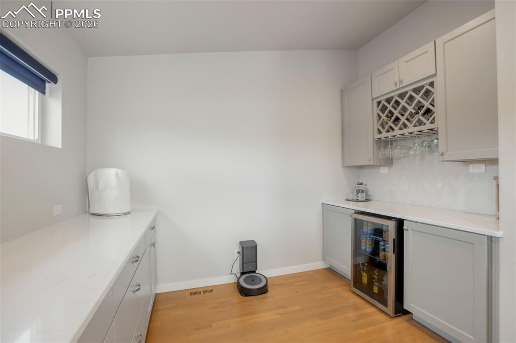 Indoor dry bar off of kitchen, featuring, wine rack, mini fridge, real white oak wood finished floors