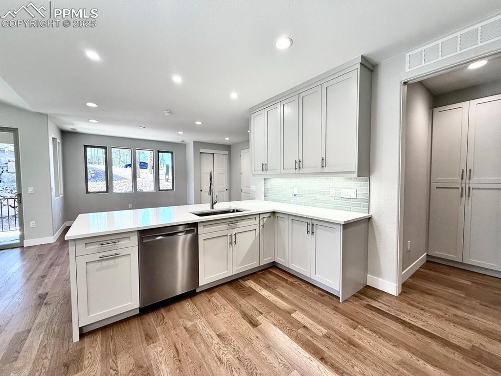 Full-sized Gourmet Kitchen with Quartz Countertops, Upper Cabinets to the Ceiling, Under-cabinet lighting., Induction Range, Included Stainless Still Fridge, and Wood Flooring.