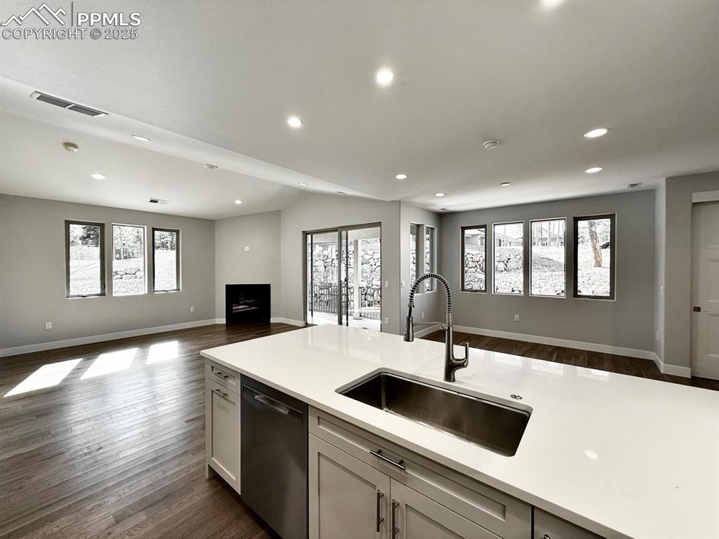 Full-sized Gourmet Kitchen with Quartz Countertops, Upper Cabinets to the Ceiling, Under-cabinet lighting., Induction Range, Included Stainless Still Fridge, and Wood Flooring.