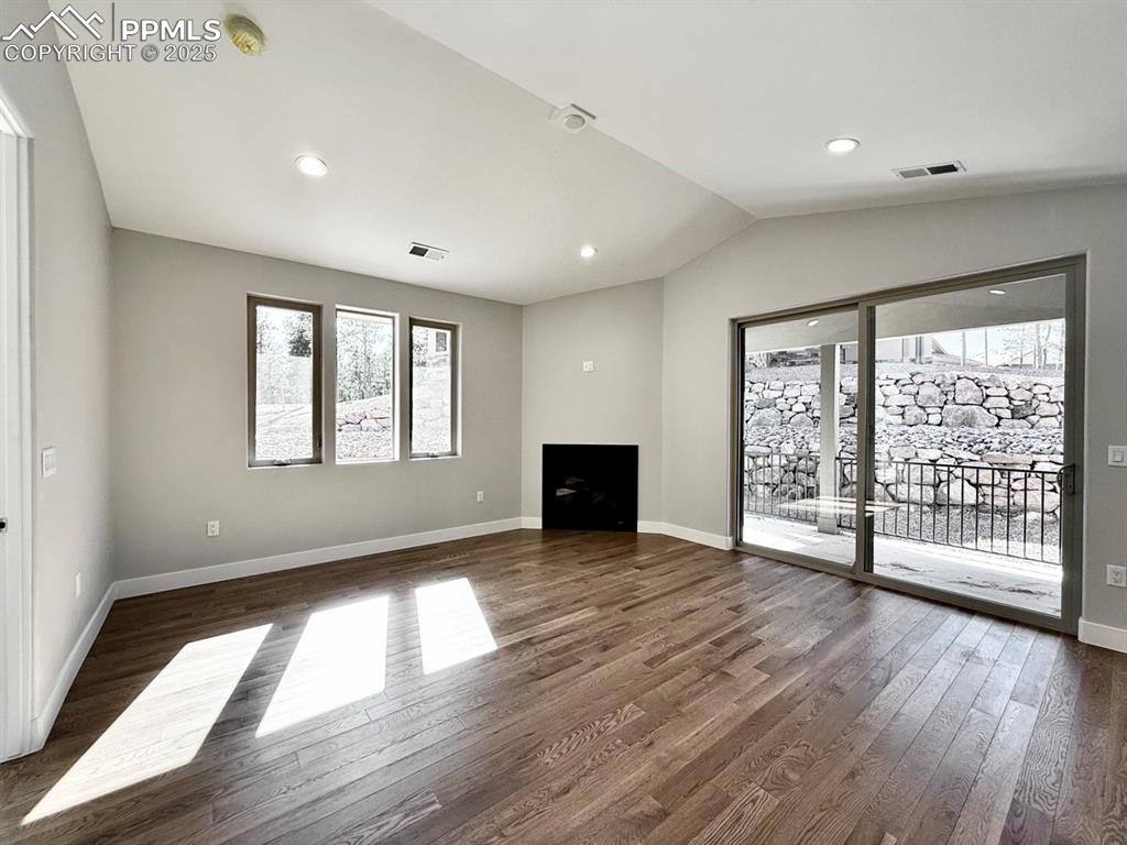 Vaulted Living Room with Gas Fireplace and Sliding Door to Covered Patio.