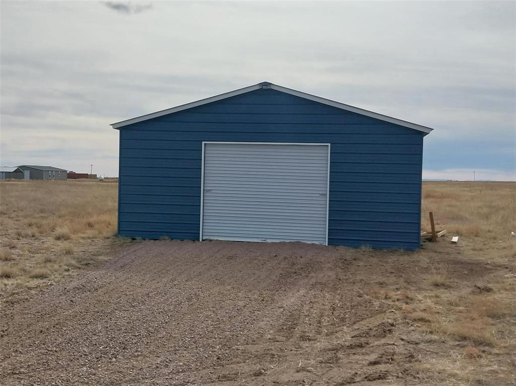 Detached garage with dirt driveway