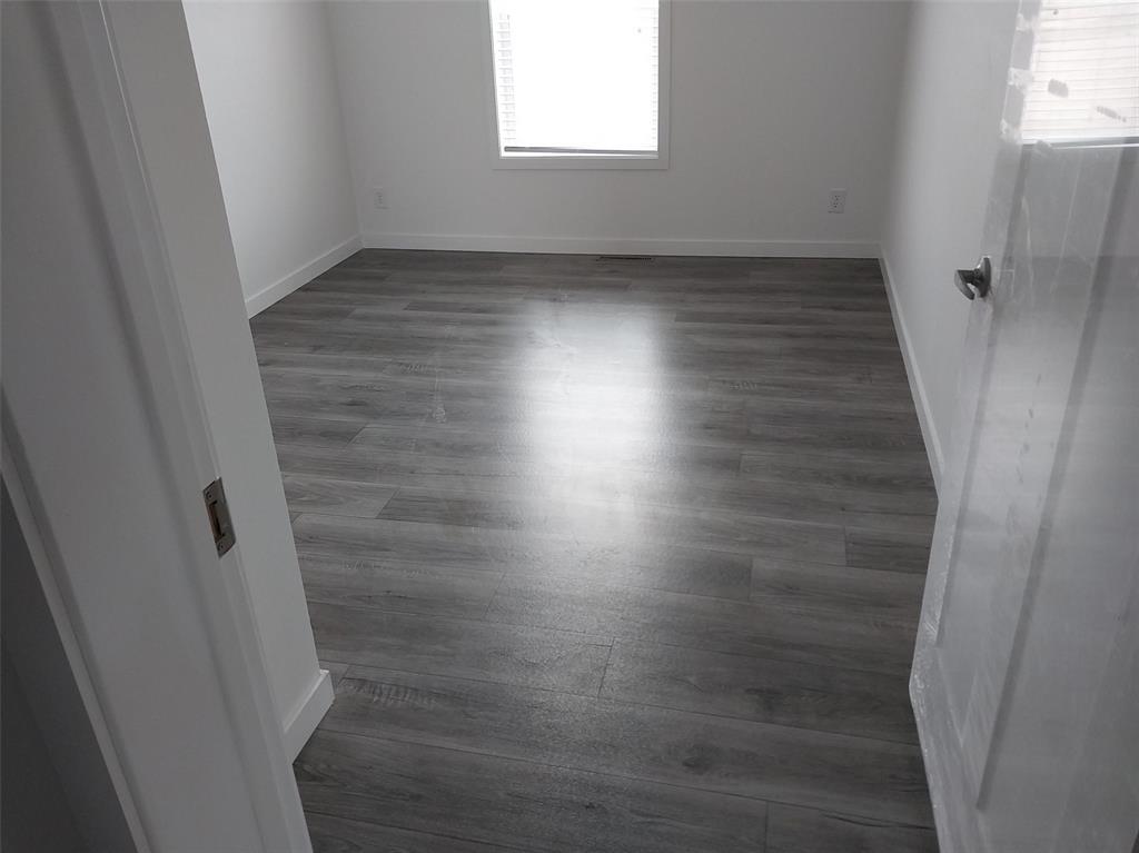 Empty room with baseboards and dark wood finished floors