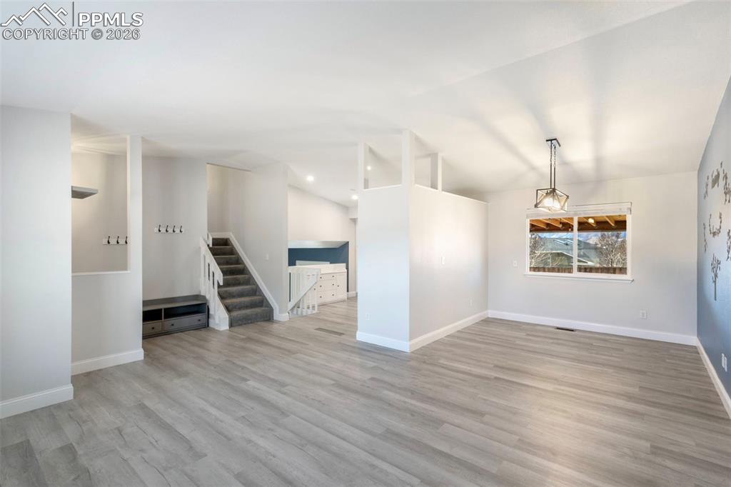 Formal Living Room view toward Dining Room, Kitchen, Foyer, and staircase to upper level