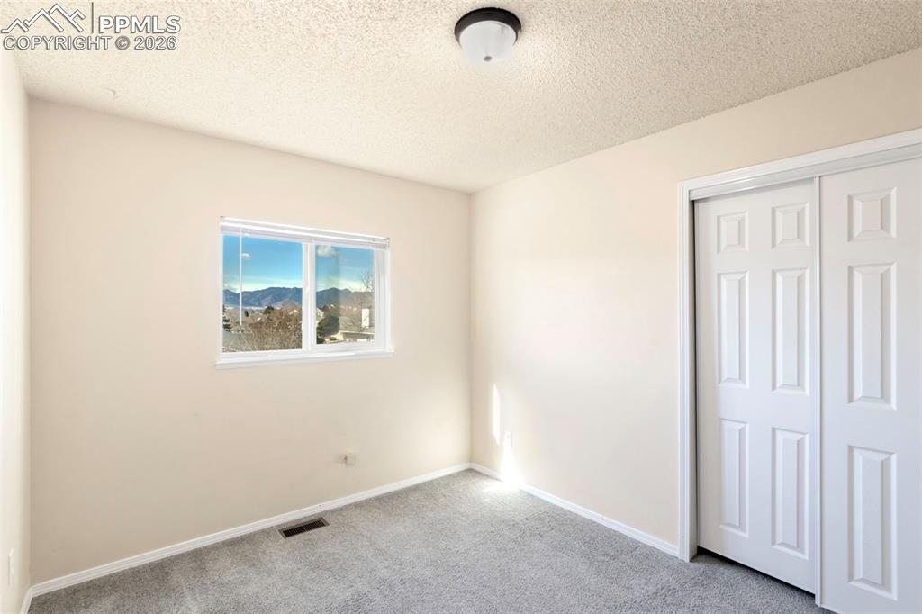 Secondary bedroom that is situated on the West side of the house and features incredible Pikes Peak and the full Front Range mountain views