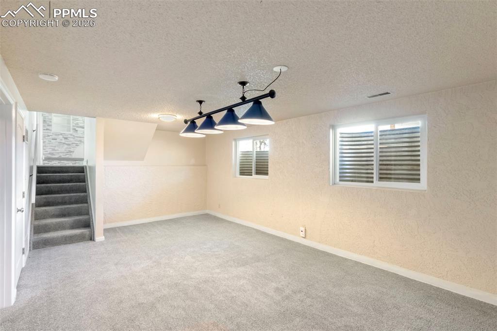 Basement Rec Room features light colored carpet and pool table suspended lighting