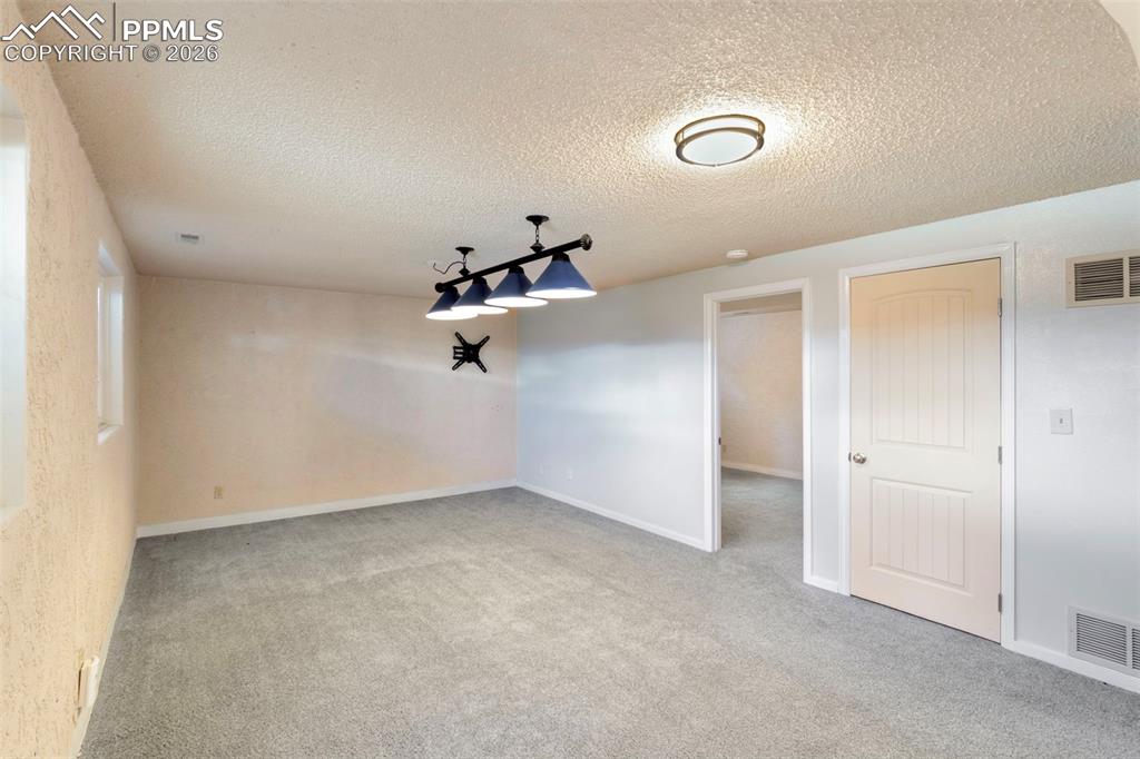 Basement Rec Room with light carpet.  Fourth bedroom with adjoining bath on this level as well as the mechanical room and unfinished storage