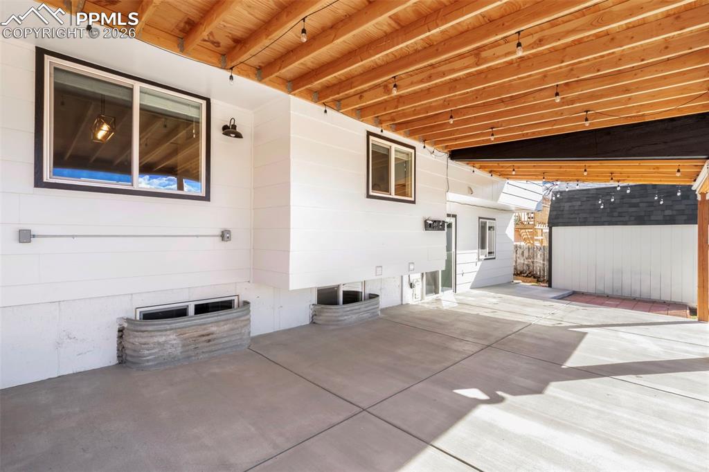 40'x16' covered patio with strung Edison lights and roll-down shades for comfort from the late afternoon sun.  This area is perfect for outdoor entertaining and features Pikes Peak and Front Range views