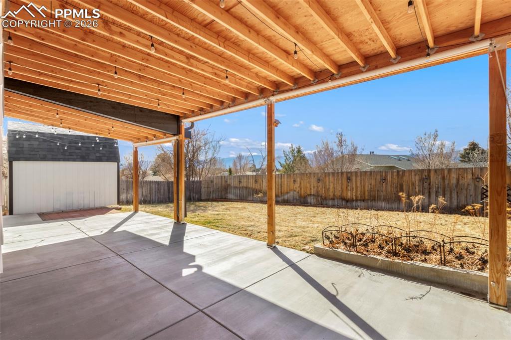 Fenced backyard with a covered patio area