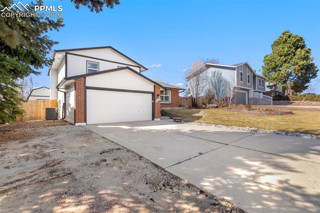 View of Side with driveway, brick and masonite siding, and an oversized 2-car garage