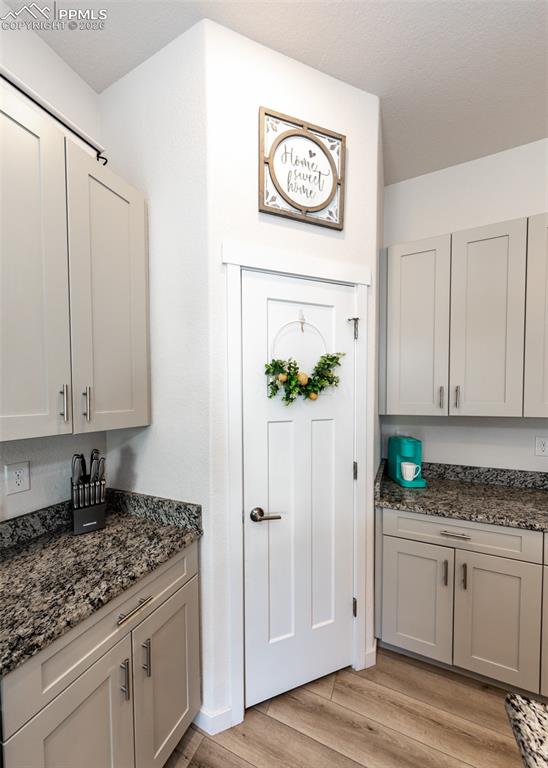 Kitchen with dark stone counters and light wood-style floors
