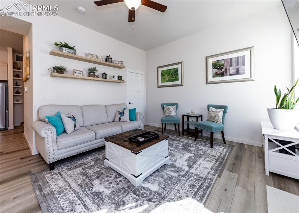 Living area featuring ceiling fan and light wood-style flooring