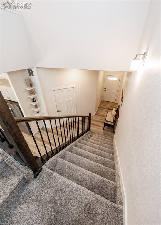 Staircase featuring carpet floors and baseboards