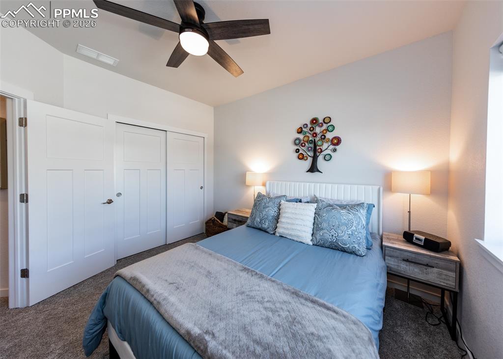 Carpeted bedroom featuring a closet and ceiling fan