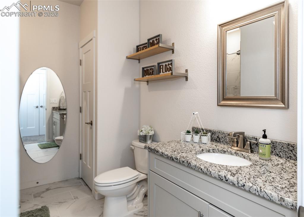 Bathroom with vanity and light marble finish floors