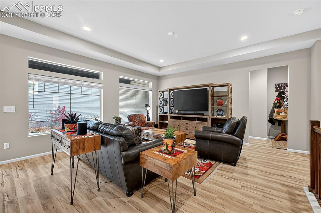 Living area with light wood finished floors, plenty of natural light, and recessed lighting