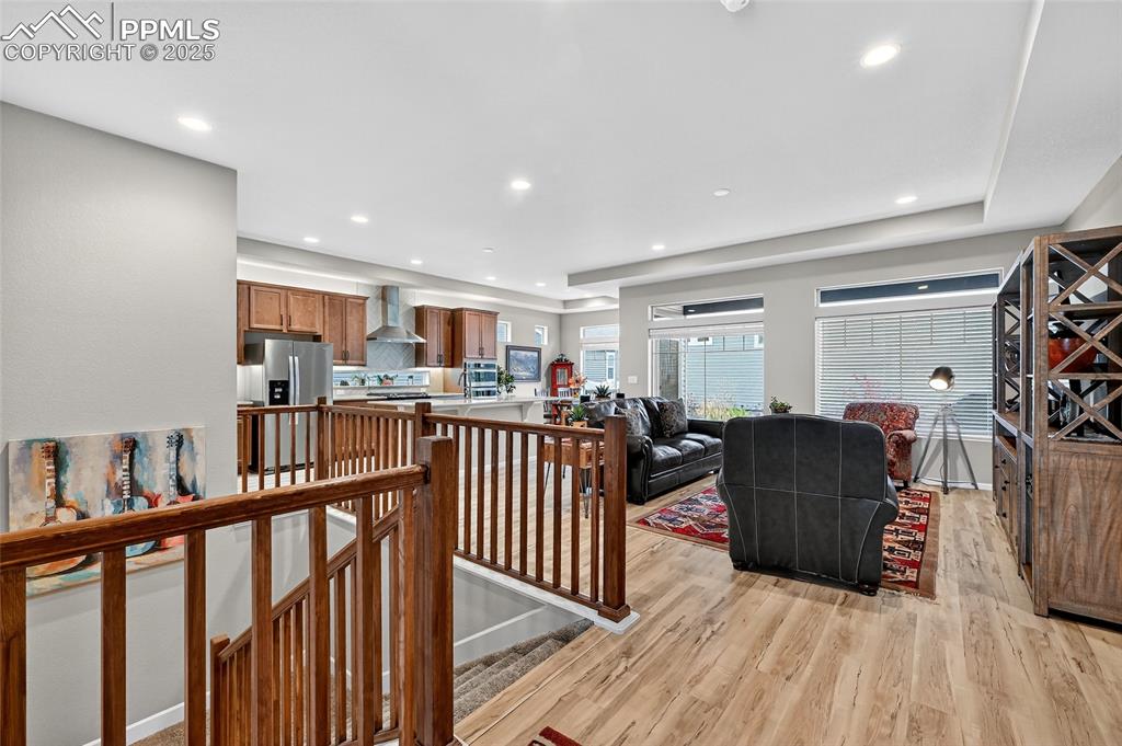 Living room with light wood-style floors, recessed lighting, and a tray ceiling