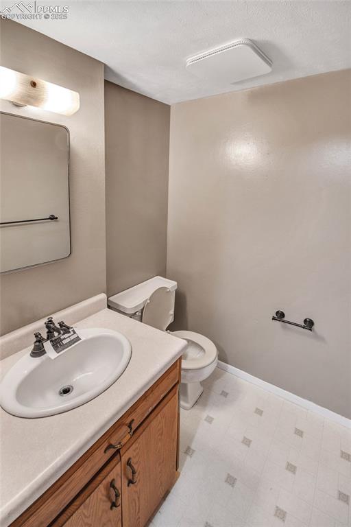 Bathroom featuring tile patterned floors, toilet, and vanity