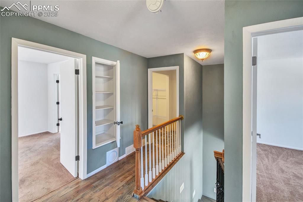 Hall featuring baseboards, carpet flooring, and an upstairs landing
