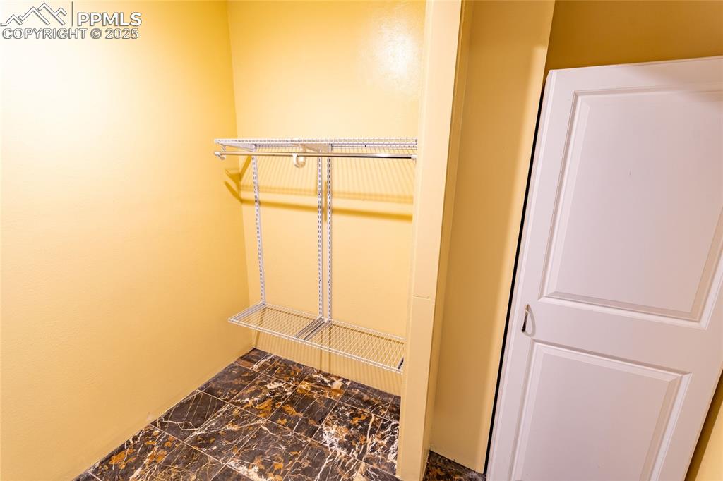 Spacious closet featuring marble finish floor