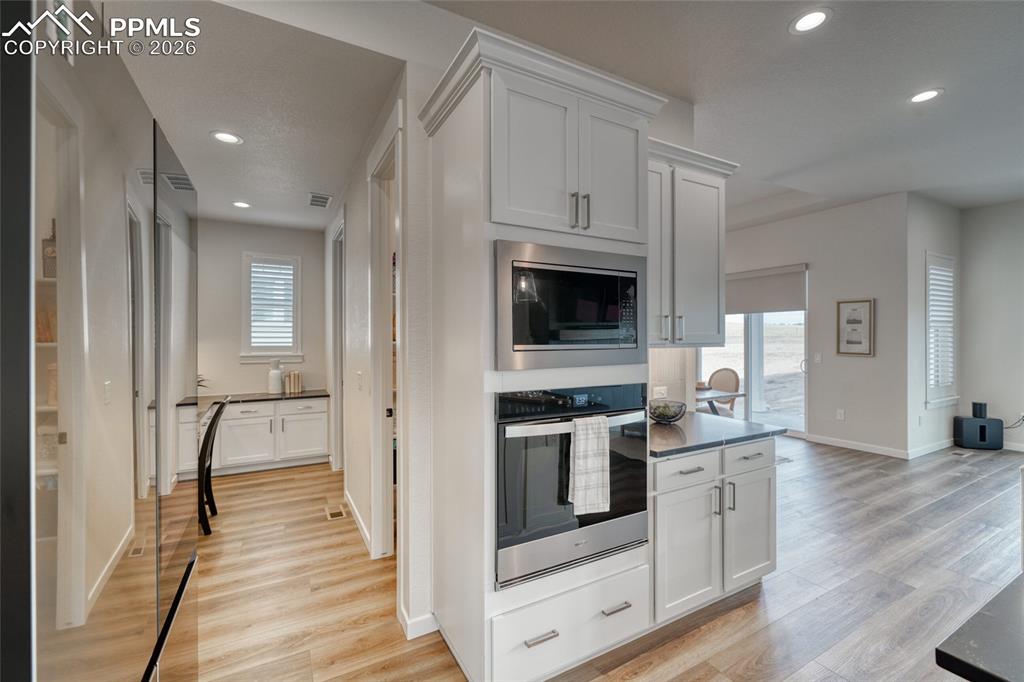 Kitchen featuring white cabinetry, stainless steel appliances, light wood-type flooring, and recessed lighting