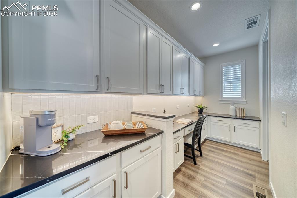 Laundry room with light wood finished floors and recessed lighting