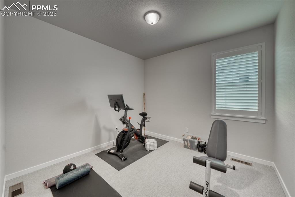Workout area with carpet and a textured ceiling