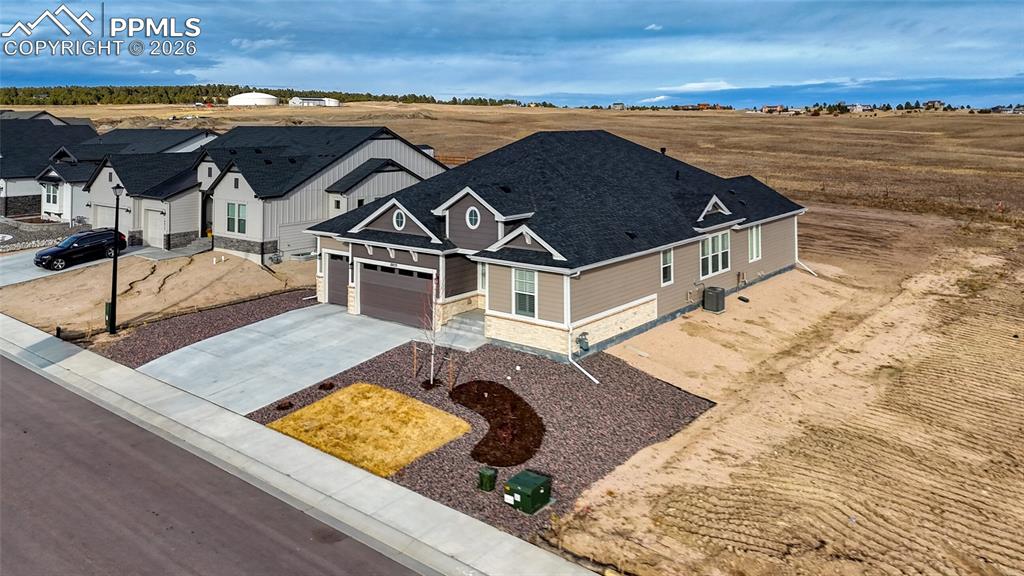 View of front of house with concrete driveway, stone siding, and an attached garage