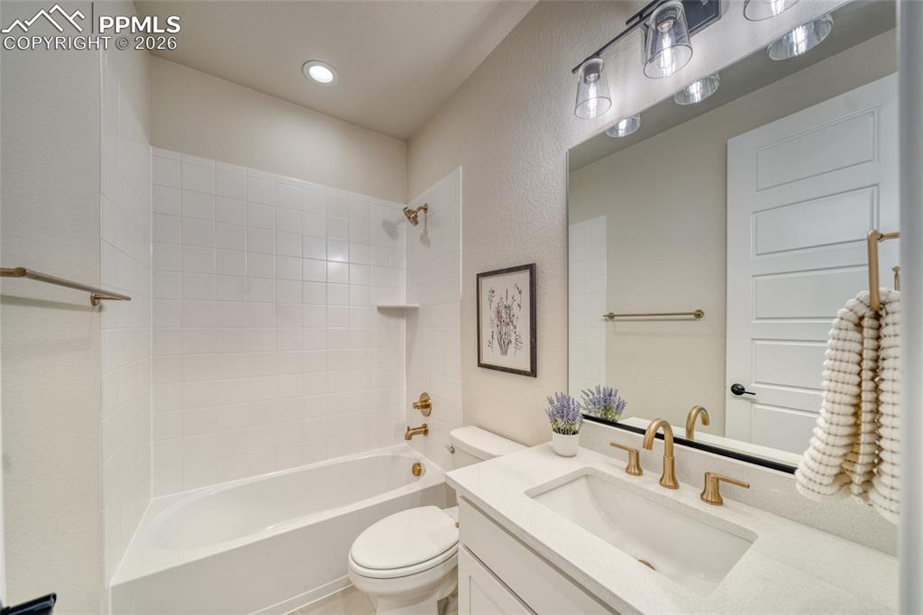 Bathroom with vanity, shower / washtub combination, a textured wall, and recessed lighting