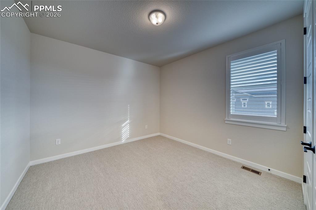 Unfurnished room with baseboards and light carpet