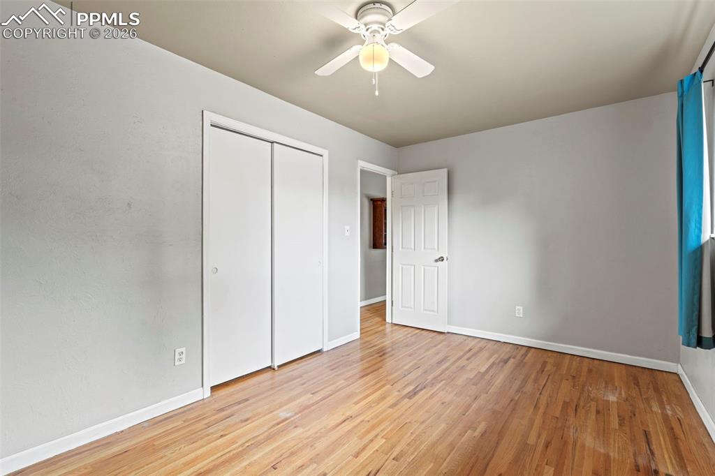 Unfurnished bedroom with light wood-style flooring, a closet, and ceiling fan