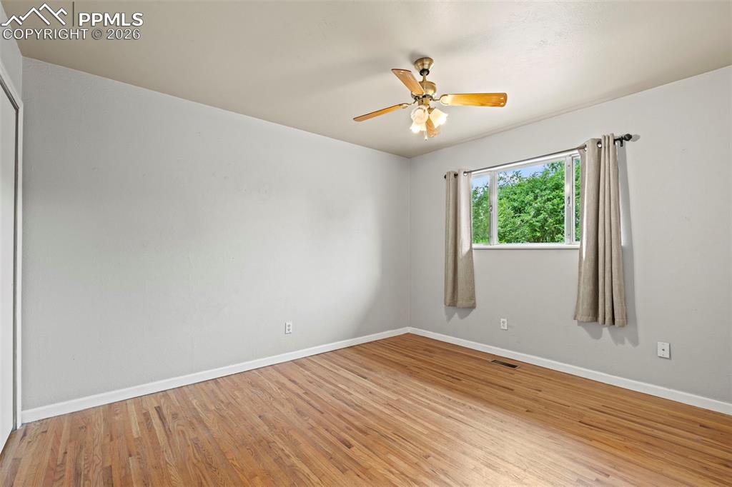 Empty room featuring light wood-style floors and ceiling fan