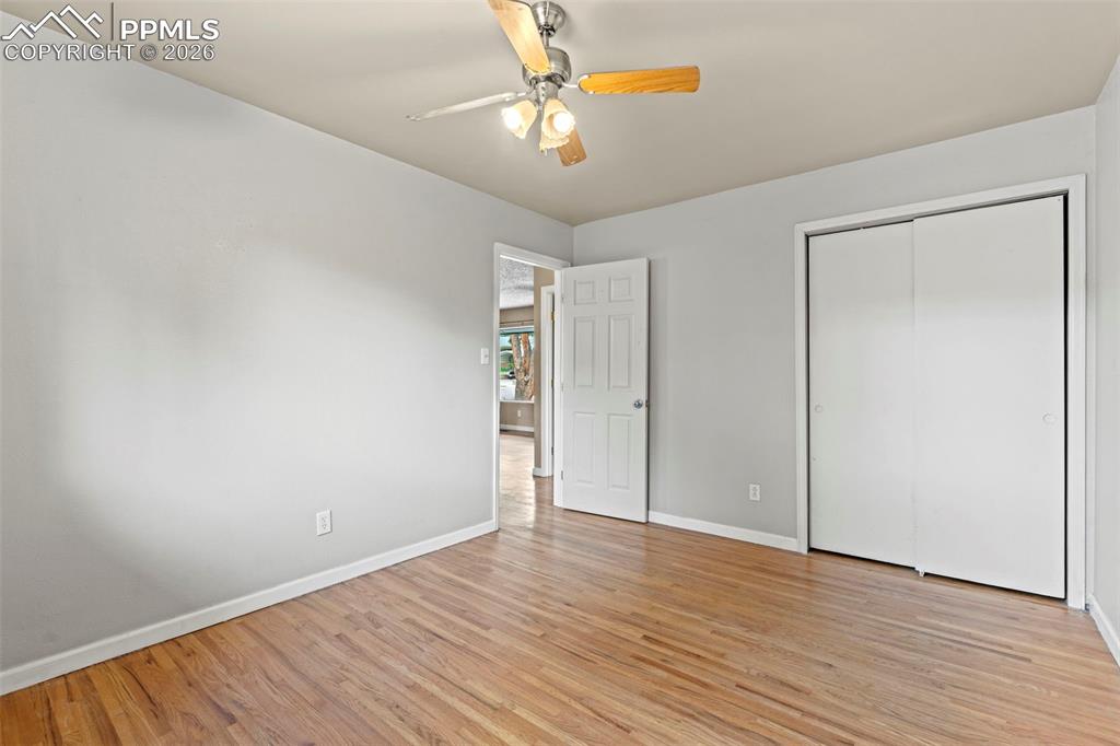Unfurnished bedroom with a ceiling fan, light wood finished floors, and a closet