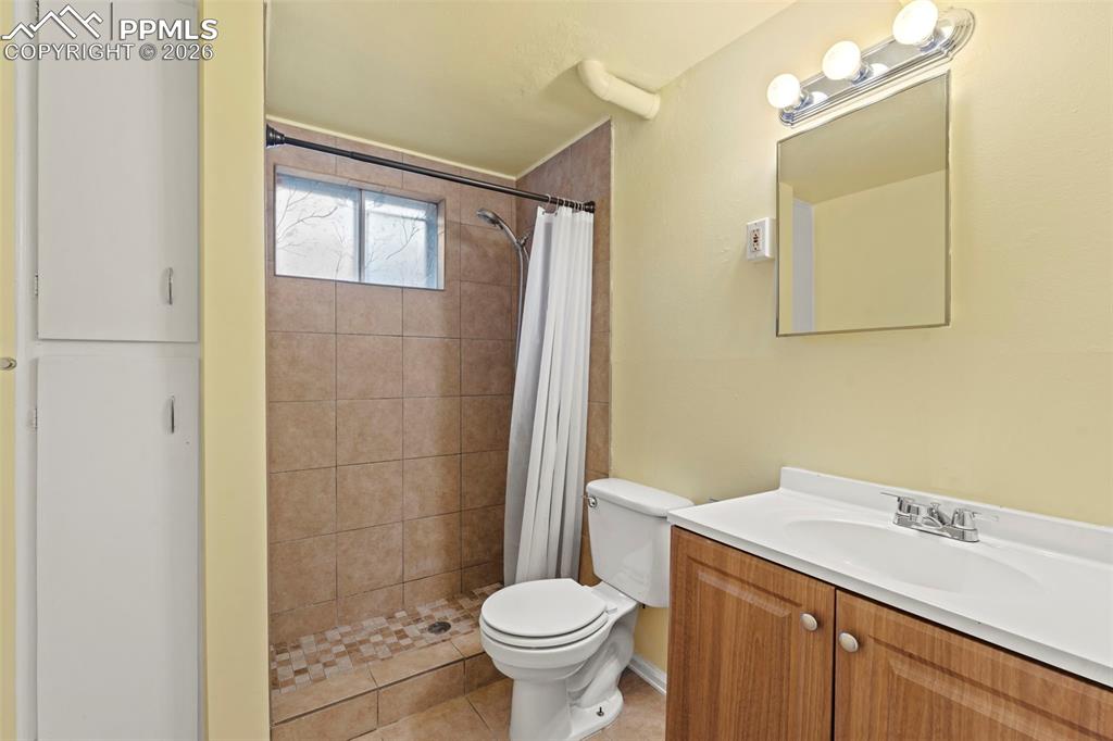 Bathroom with vanity, a shower stall, and light tile patterned floors