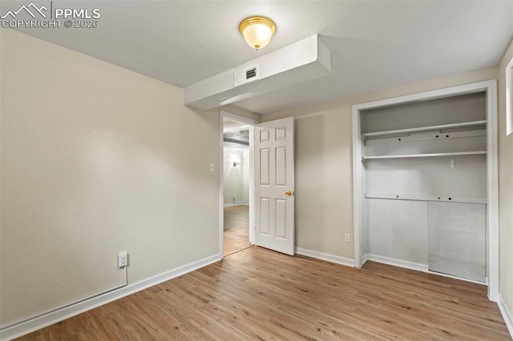 Unfurnished bedroom featuring light wood-style flooring and a closet