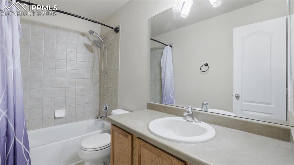 Upper Level Primary Bathroom with vanity, mirror, and tiled tub/shower.