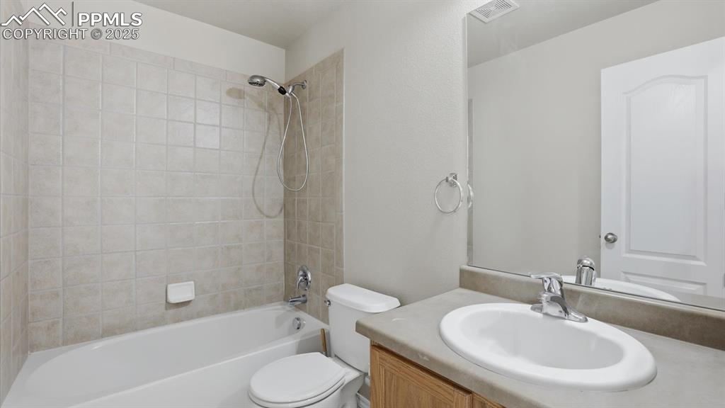 Upper Level Full Bathroom with vanity, mirror, and tiled tub/shower.