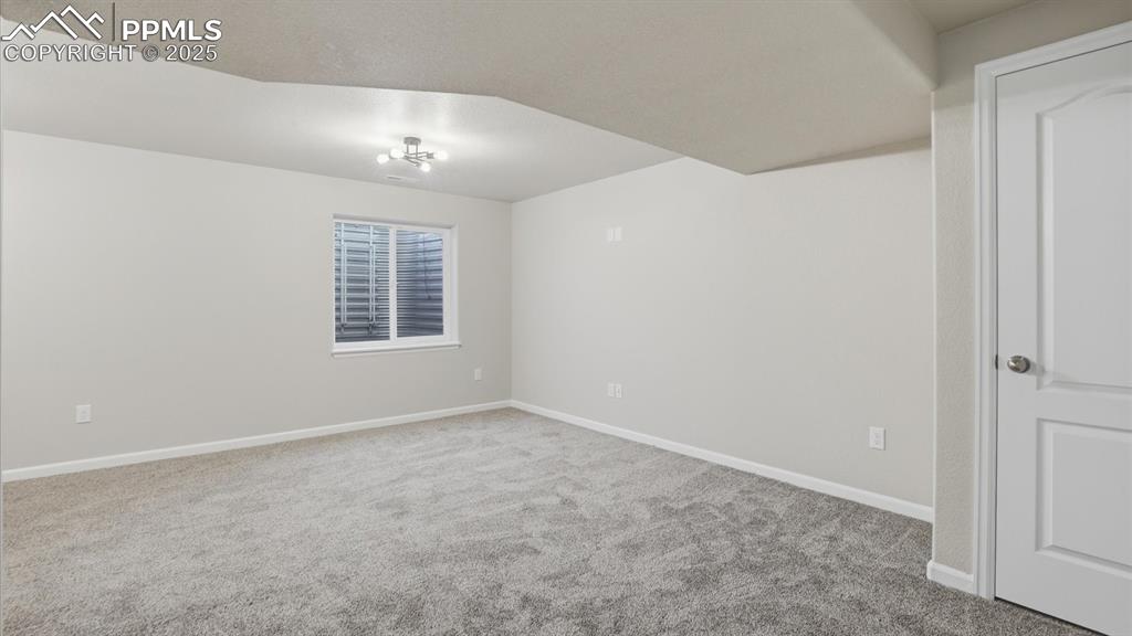 Basement Family Room with neutral carpet and modern light fixture.