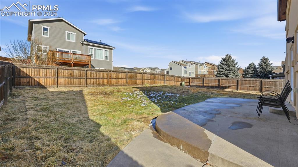 Fenced backyard and concrete patio.