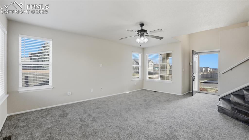 Spacious Living Room with new carpet and lighted ceiling fan.