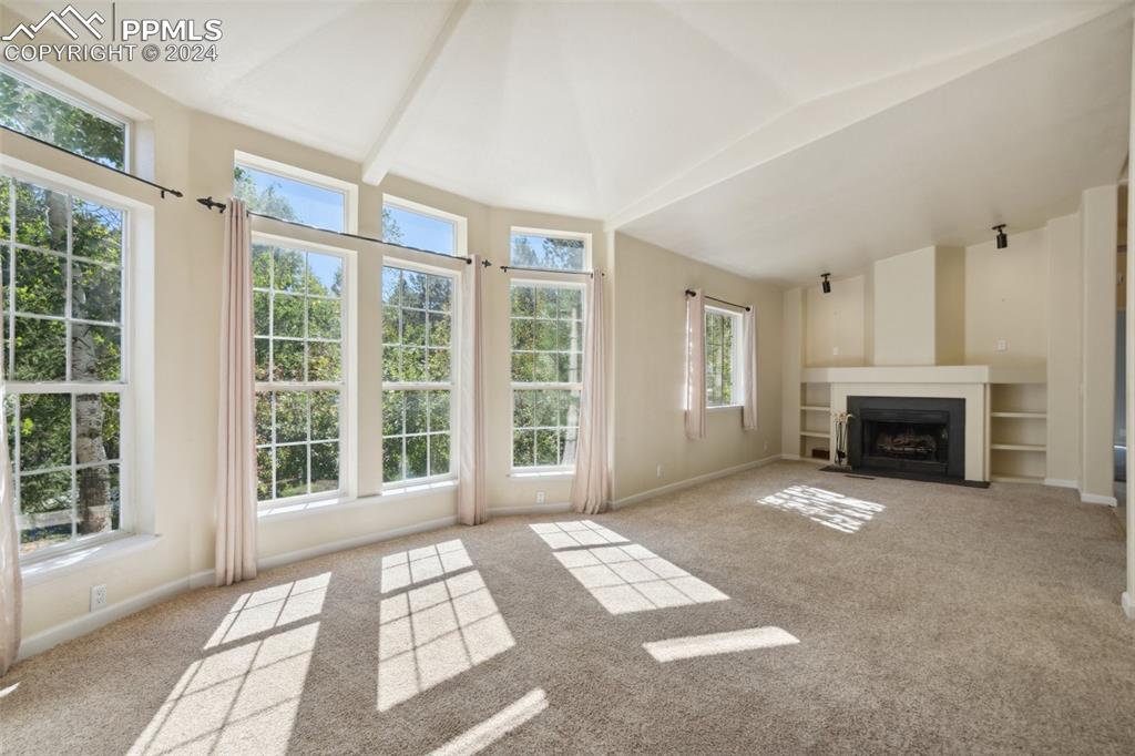  Living room featuring lofted ceiling with beams and light colored carpet