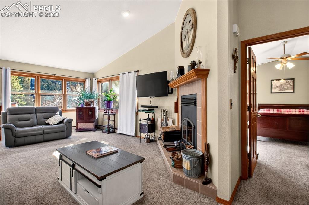 Living room with wood burning fireplace. Also a view of the primary bedroom