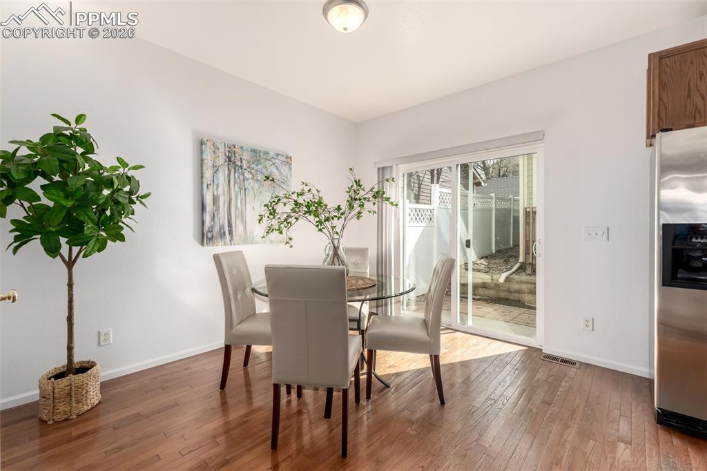 Dining space with hardwod flooring and slider to back patio