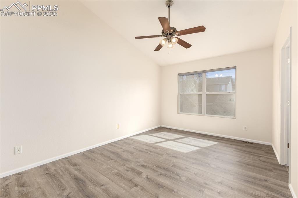 Primary bedroom with vaulted ceiling, LVP floors and an en-suite bathroom 