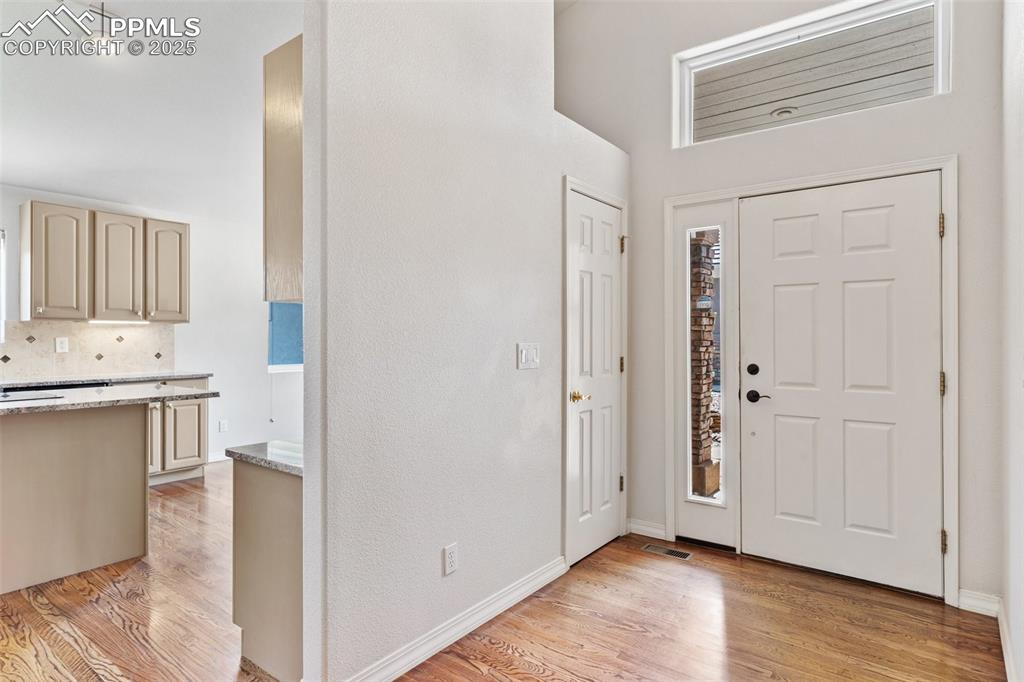 Foyer with light wood-type flooring and baseboards
