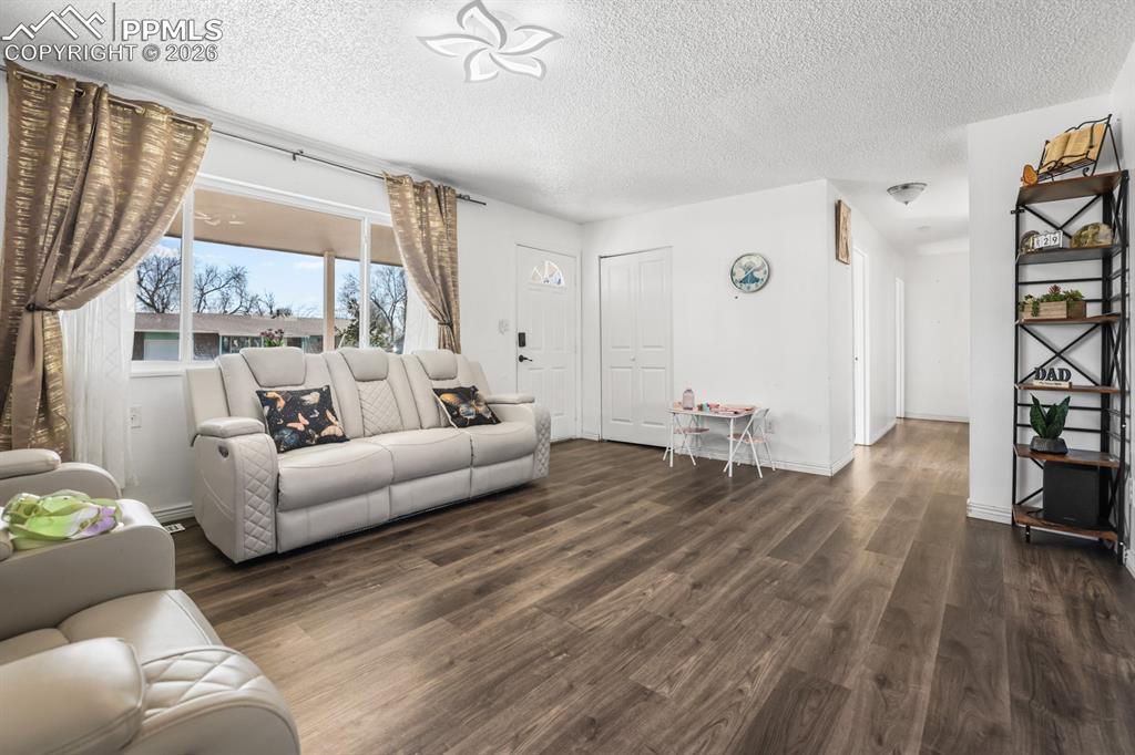 Living room with wood finished floors and a textured ceiling