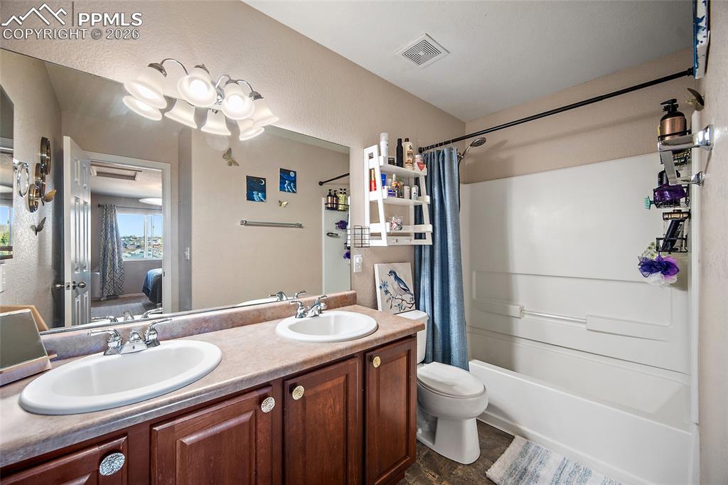 Primary bathroom featuring double vanity and shower/ bath combo