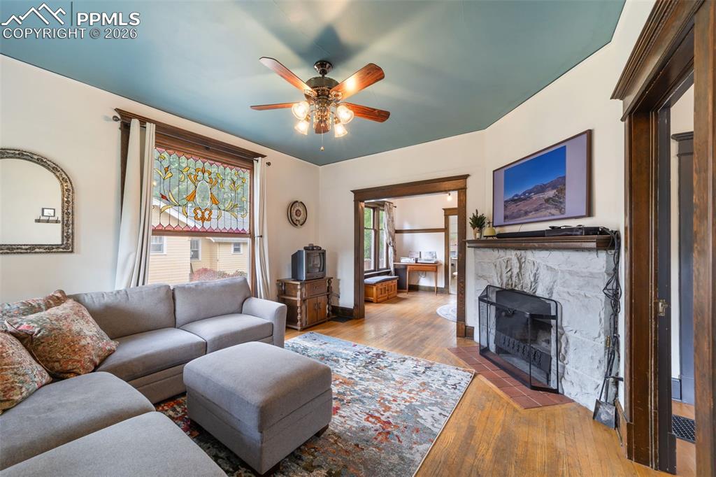 Entry and living room featuring hardwood floors and a wood burning fireplace