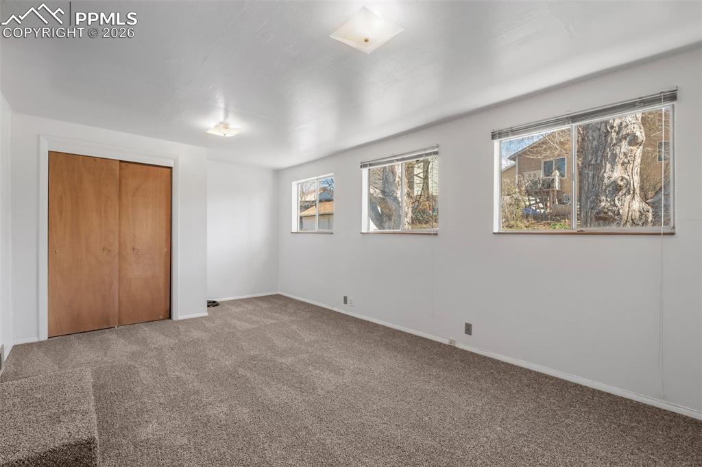 Bedroom 2 featuring a closet, plenty of windows and new carpeted floors