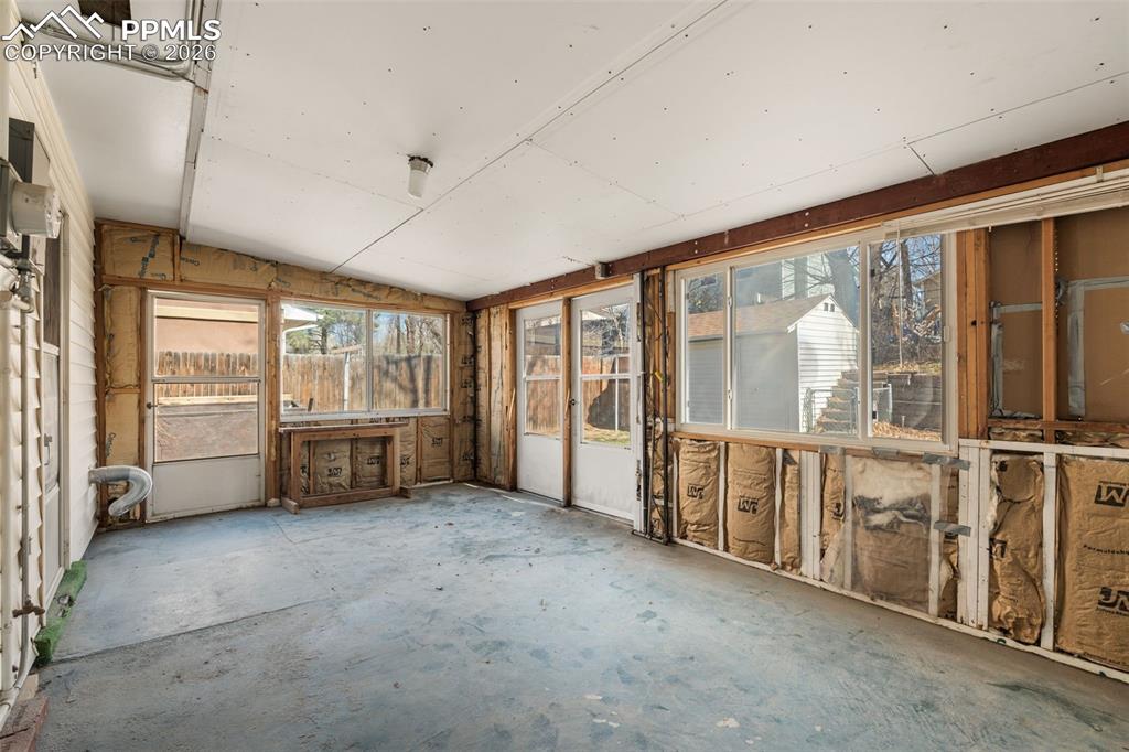 Unfurnished sunroom with lofted ceiling and concrete flooring