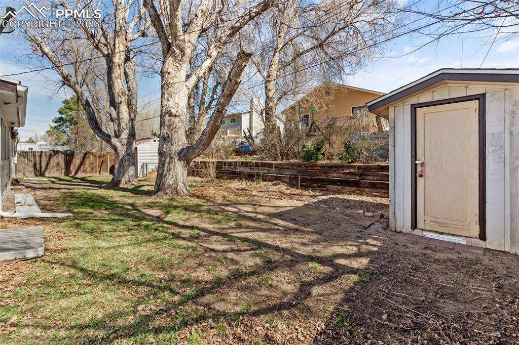 Fenced backyard with a storage shed